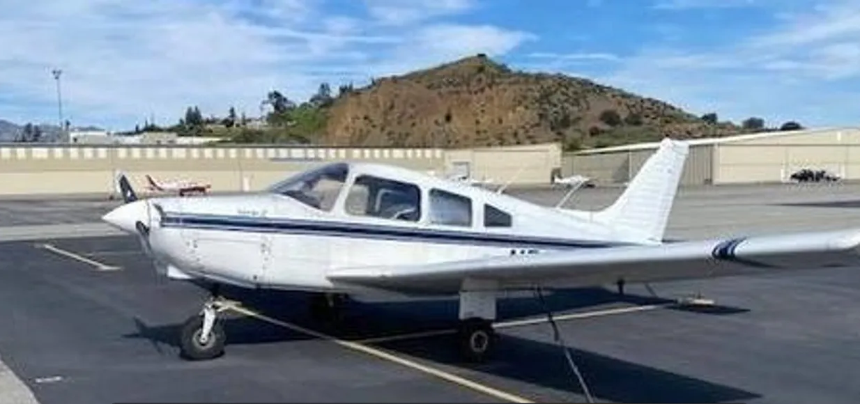 A small white airplane parked in an airport lot.