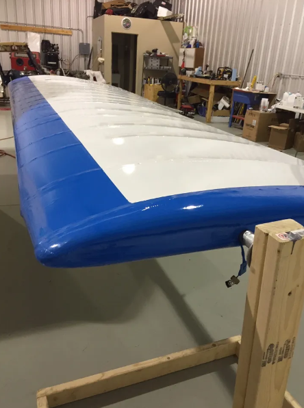 A blue and white inflatable boat in the middle of a workshop.