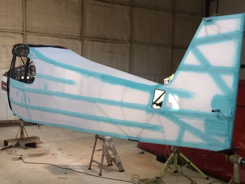 A blue and white plane sitting in an airplane hanger.