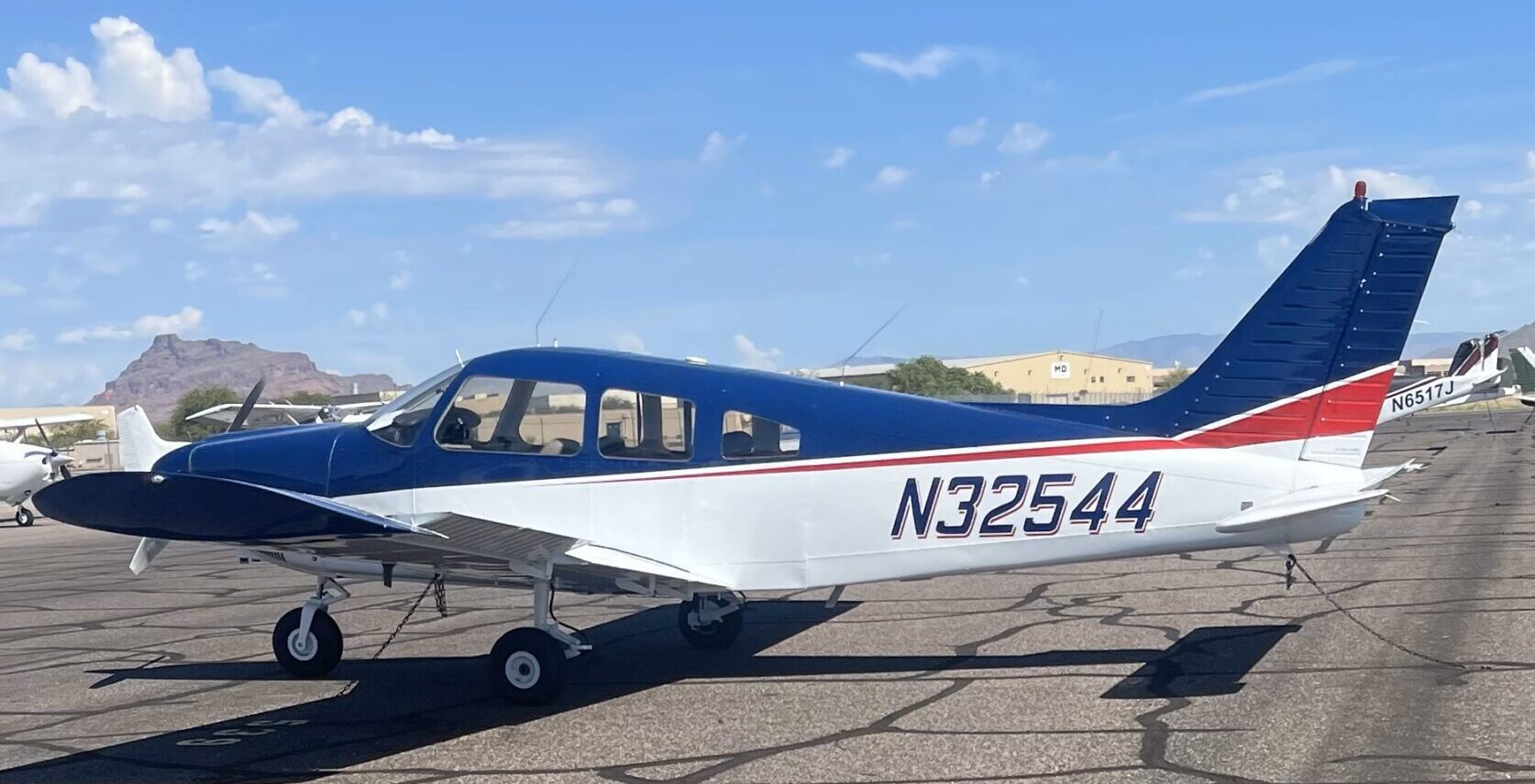 A small blue and white plane sitting on top of an airport runway.